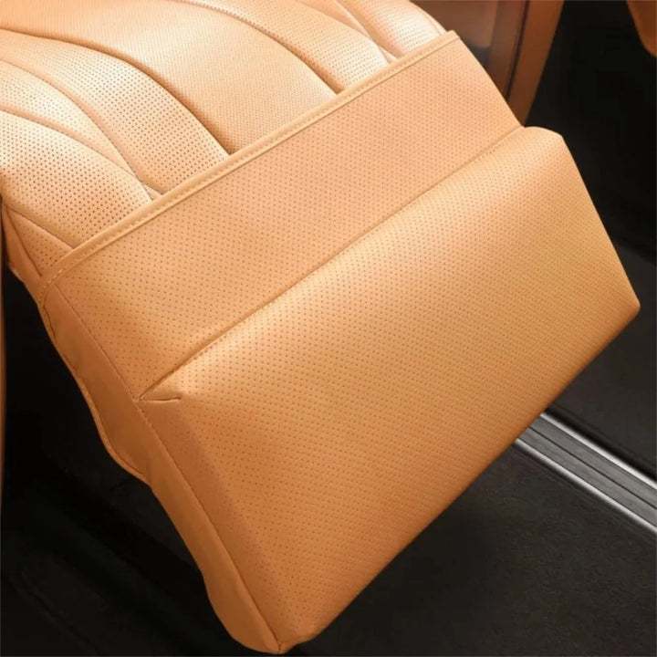 Close-up of a tan perforated leather car seat armrest with professional stitching.