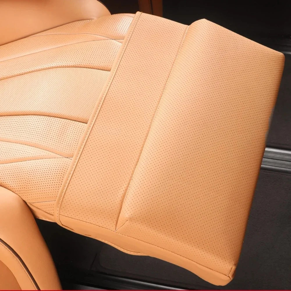 Close-up of tan perforated leather car seat upholstery with detailed stitching.
