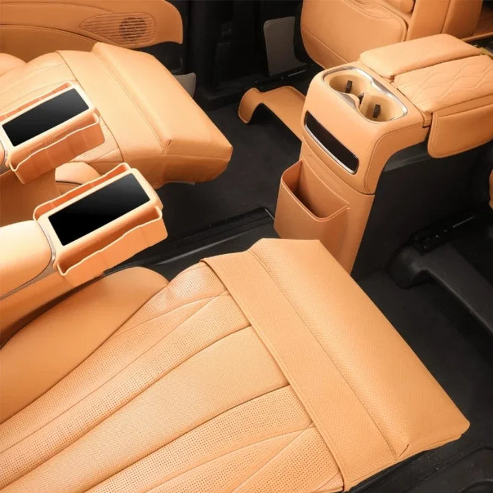 Luxury tan perforated leather car interior with center console and rear seat entertainment screens